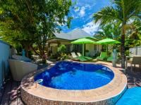a swimming pool in a backyard with a blue pool at Maison Charme De L&#39;ile in La Digue