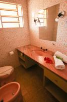 a bathroom with a sink and a toilet and a mirror at Pousada Sino dos Ventos in Campos do Jordão