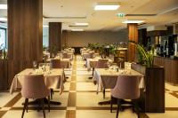 Un restaurante con mesas y sillas en una sala. en Hotel Plaža Duće, en Duće