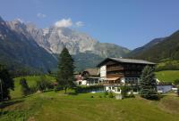una casa en un campo con montañas al fondo en Pension Schöne Aussicht, en Kuchl