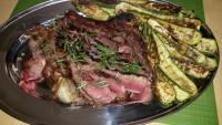 a plate of meat and vegetables on a table at Agriturismo Valle Isola "La Tana del Gusto" in Comacchio