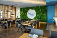 un restaurant avec des tables et des chaises et un mur végétal dans l'établissement Azure Seaview Studio in Priscilla, Caesar Blue Resort, Gym, à Kalecik