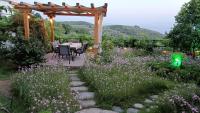 a garden with a table and chairs under a pergola at Mikros Paradisos Pelion in Áyios Vlásios