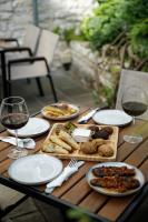 a wooden table with plates of food and glasses of wine at Hotel Kalemi 2 in Gjirokastër