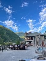 a group of people sitting at tables in front of a building at Senger Qala in Qax