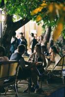 Un grupo de personas sentadas en sillas en un restaurante. en Olive hotel, en Ereván