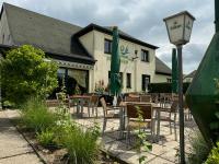 un restaurant avec des tables et des chaises devant un bâtiment dans l'établissement "Am Yachthafen", à Seedorf