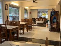 un restaurante con mesas y sillas y una máquina de refrescos en Hotel Kalyani, en Nandaprayāg