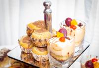 um grupo de bolos e cupcakes em uma prateleira de vidro em Airport West Hotel em Accra