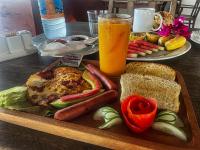 a tray of food with a sandwich and a glass of orange juice at AVO Boutique Hotel in Dikoni