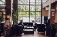 Ein Mann, der auf einem Handy in einem Büro redet. in der Unterkunft Park Hotel Diament Katowice in Kattowitz