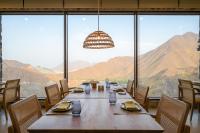 uma sala de jantar com uma mesa e vista para as montanhas em Najd Al Meqsar, By Sharjah Collection - Adults Only em Khor Fakkan