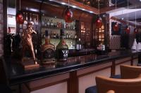 een bar met een standbeeld van een man erachter bij De Sovrani in kolkata