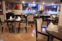 een eetkamer met tafels en stoelen in een restaurant bij De Sovrani in kolkata