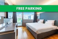 Una cama en una habitación de hotel con las palabras estacionamiento gratuito en B&amp;B HOTEL Lausanne Crissier, en Lausana
