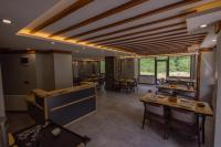 ÇamlıhemşinにあるVadi Taş Konakの木製の天井とテーブルと椅子のあるレストラン