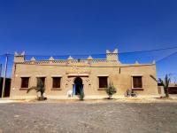 an old building with a horse in front of it at Sahara House in Merzouga