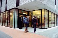 two people walking in front of a store window at De Ploate Hostel in Ostend