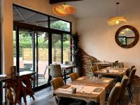 ein Restaurant mit Holztischen und Stühlen und einem Spiegel in der Unterkunft Le Clos des Arbousiers in Linguizzetta