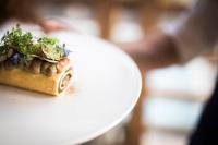 a white plate with a piece of food on it at Presulis Hideaway Apartments & Restaurant in Fiè