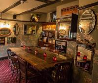 ハリッジにあるAlma Inn & Dining Roomsの赤いボールが置かれた木製テーブルが備わる部屋