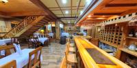 Un restaurante con barra, mesas y sillas. en Hotel casona de los ríos, en Futrono