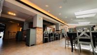 um restaurante com um bar com cadeiras e mesas em Pensiunea Waldor em Bacău