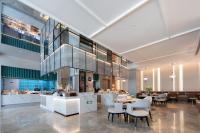 Un vestíbulo con un restaurante con mesas y sillas. en Atour Hotel Shanghai Baoshan Shangda Road, en Shanghái