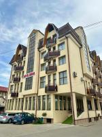 Un gran edificio con coches aparcados delante. en Hotel Diana, en Bistriţa