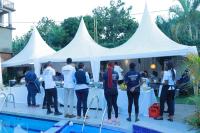 a group of people standing in front of a white tent at Mowicribs Hotel and Spa in Entebbe