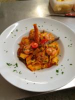 a white plate of food with shrimp and bacon at Gasthof International in Hieflau