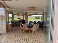 een eetkamer met tafels en stoelen en uitzicht op een golfbaan bij Domaine Lamrah in Marrakesh