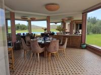 een eetkamer met een tafel en stoelen met uitzicht bij Domaine Lamrah in Marrakesh