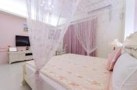 a white bedroom with a bed with a canopy at Happy House Homestay in Hualien City