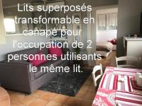ein Wohnzimmer mit einem Bett und einem Tisch in der Unterkunft Les Grimaldines - Maison d&#39;Hôtes in Cagnes-sur-Mer