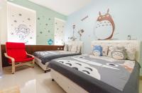 a bedroom with two beds and a red chair at Happy House Homestay in Hualien City