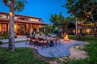 Un grupo de personas sentadas alrededor de una mesa frente a una fogata. en LÀNG MẮM - PAMY Homestay 2, en Phú Hiệp