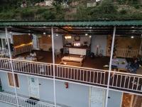 an overhead view of a building with people sitting on the balcony at The Rare One's Mukteshwar - Resort & Cafe in Mukteswar