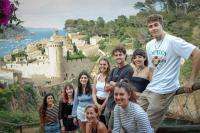 un grupo de personas de pie en frente de un castillo en Mana Mana Youth Hostel, en Tossa de Mar