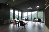 a dining room with tables and chairs and large windows at Cone Hotel Dilijan, By One in Dilijan