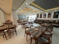 Un comedor con mesas y sillas de madera. en Ohu Palace, en Ferganá