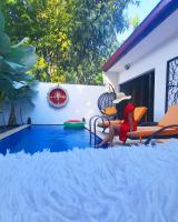 a woman sitting in a chair next to a swimming pool at King's Home Villa in Bantul