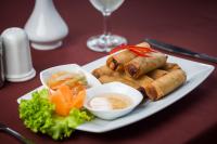 Een bord met eten, broodjes en groenten op tafel. bij Villa Phum Khnar in Phumĭ Réach Born (1)