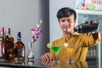 Een man die een drankje in een martini glas giet. bij Villa Phum Khnar in Phumĭ Réach Born (1)