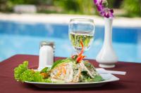 een bord salade en een glas wijn op een tafel bij Villa Phum Khnar in Phumĭ Réach Born (1)