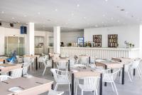 una sala da pranzo con tavoli e sedie bianche di Papantonia Hotel a Protaras