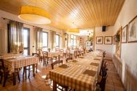 ein Esszimmer mit Tischen, Stühlen und Fenstern in der Unterkunft Agriturismo Mazzeracca in Bassano del Grappa