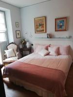 Un dormitorio con una cama grande con almohadas rosas. en A room in the &#39;borgo&#39;, en Dogliani