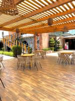 Un patio con mesas y sillas bajo un techo de madera. en Hotel El Jaguar, en San Martín de las Pirámides