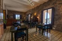 een restaurant met tafels en stoelen en een stenen muur bij La Torre del Vilar in Santa Eulalia de Ríuprimer